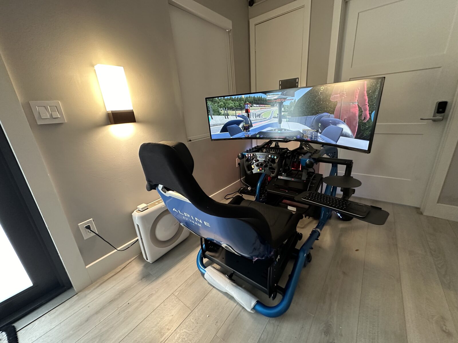 Blue-framed racing simulator with an ultrawide screen at home