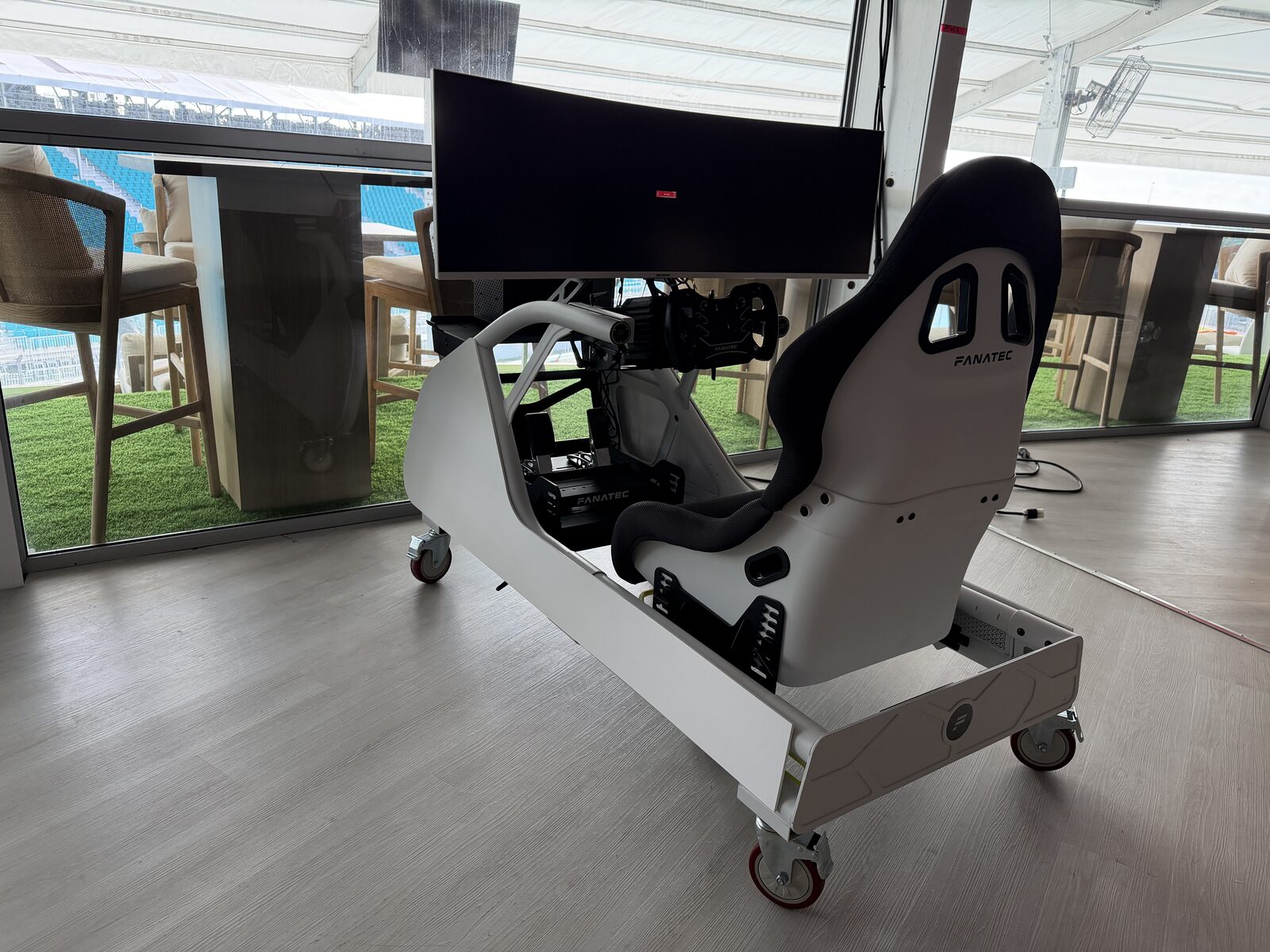 White racing simulator cockpit in a bright modern space